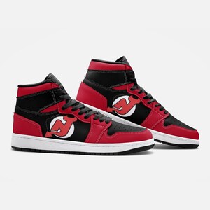 May include: A pair of red and black high-top sneakers with a white logo of a stylized 'N' on the side. The logo is red and white.