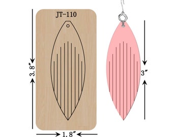 Könnte beinhalten: Ein Holzstempel zum Basteln von Ohrringen, misst 9,65 cm x 4,57 cm, neben einem fertigen rosa Ohrring, 7,62 cm lang. Der Stempel ist mit "JT-110" beschriftet und zeigt ein blattartiges Design mit vertikalen Linien. Der Ohrring hat einen silbernen Haken.