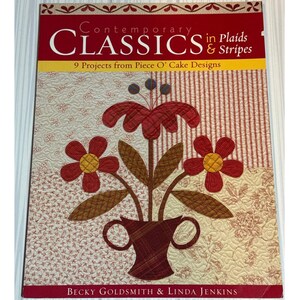May include: A softcover book titled Contemporary Classics in Plaids & Stripes: 9 Projects from Piece O' Cake Designs by Becky Goldsmith & Linda Jenkins. The cover features a quilted floral arrangement in a vase against a patchwork background.