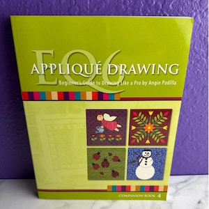 May include: A softcover book titled EQ6 Appliqué Drawing: Beginner's Guide to Drawing Like a Pro by Angie Padilla. The lime green cover features four square illustrations of an angel, a flower, ladybugs, and a snowman, with colorful stripes.