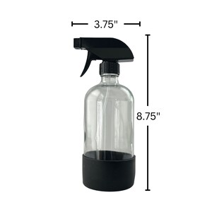 Op de afbeelding: Een transparante glazen spuitfles met een zwarte trekker-spuitkop en een zwarte siliconen basis. De fles is 22,2 cm hoog en 9,5 cm breed.