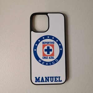 May include: White phone case with a black border featuring the Deportivo Cruz Azul logo in blue, red, and white. The name "MANUEL" is printed in blue below the logo. The case is designed for a smartphone.