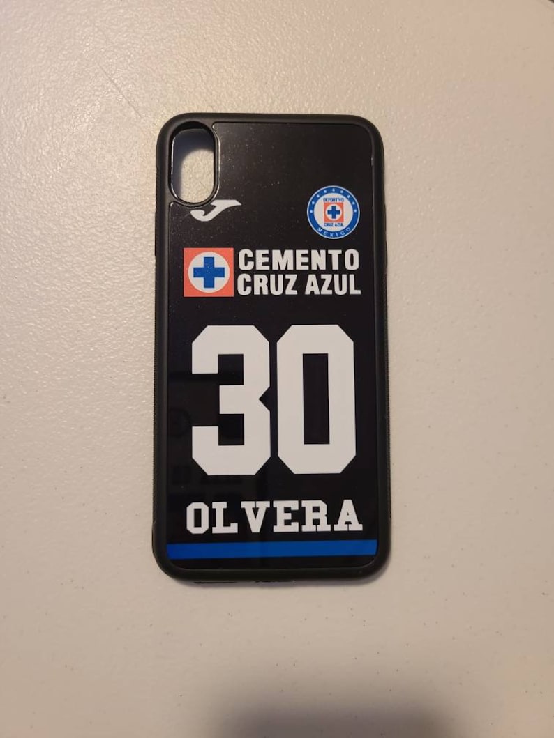 May include: Black phone case featuring the Cemento Cruz Azul logo and the number 30 with the name OLVERA in white. The case has a black border and a blue stripe at the bottom. The case is designed for a smartphone.