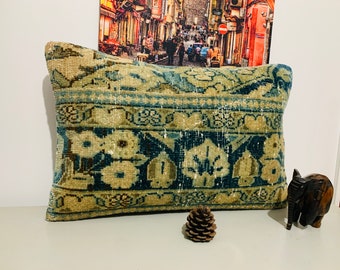 May include: A rectangular pillow with a blue and beige floral pattern. The pillow is made from a woven fabric with a distressed look.