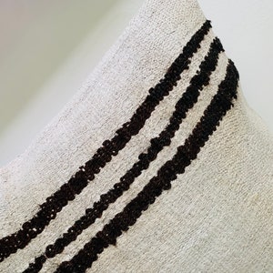May include: A white throw pillow with three black stripes running diagonally across the front.