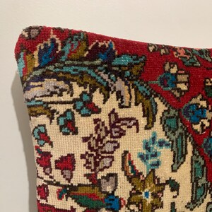 Puede incluir: Una almohada con estampado rojo, blanco y azul con un dise&ntilde;o floral. La almohada est&aacute; hecha de una tela suave y tejida.