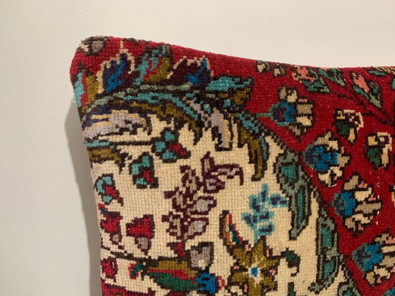 Puede incluir: Una almohada con estampado rojo, blanco y azul con un dise&ntilde;o floral. La almohada est&aacute; hecha de una tela suave y tejida.