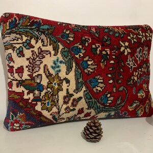 Puede incluir: Una almohada rectangular con un dise&ntilde;o floral rojo, blanco y azul. La almohada est&aacute; hecha de un tejido suave y tejido.