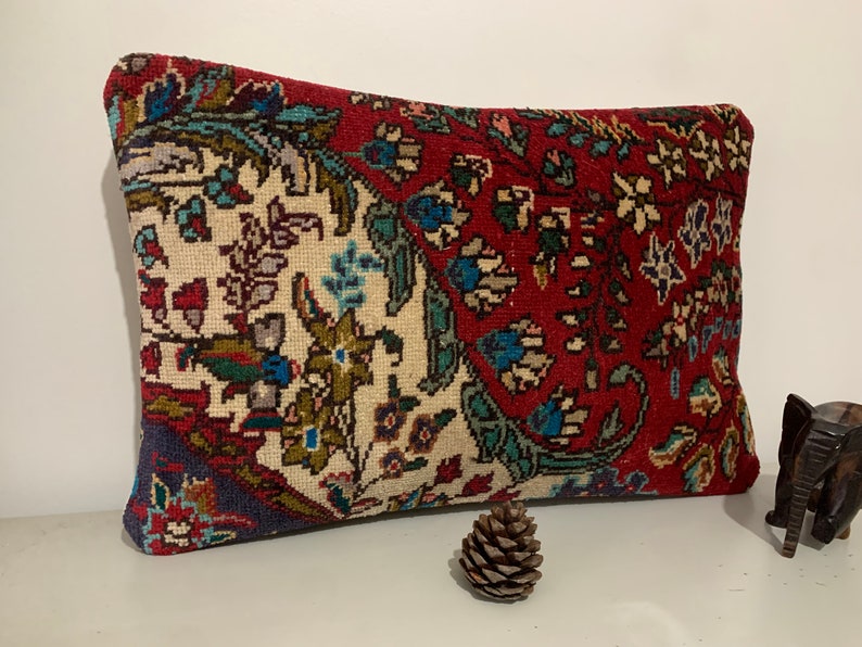 Puede incluir: Una almohada rectangular con un dise&ntilde;o floral rojo, blanco y azul. La almohada est&aacute; hecha de un tejido suave y tejido.