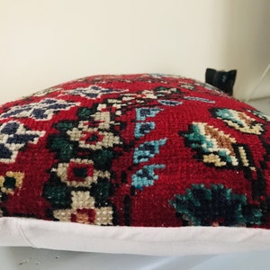 Puede incluir: Coj&iacute;n rojo, azul y verde con estampado y borde blanco. El coj&iacute;n est&aacute; hecho de una tela suave y mullida.