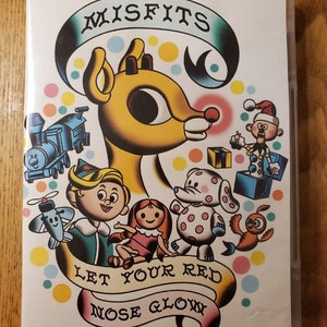May include: A DVD case with a colorful illustration of a cartoon reindeer and other Christmas characters. The text "Misfits Let Your Red Nose Glow" is printed on the case.