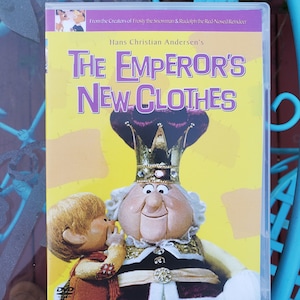 May include: DVD case for The Emperor's New Clothes, a 20th anniversary edition animated film based on the Hans Christian Andersen story. The cover features a cartoon illustration of the Emperor and a young boy.