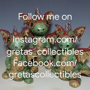 May include: Three green and gold ceramic dragon figurines with red accents and goggles. The dragons are sitting on a grey surface. The text "Follow me on Instagram.com/gretas_collectibles Facebook.com/gretascollectibles" is written on the image.