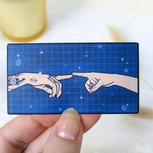 May include: Two hands reach out to touch each other, their fingertips almost meeting. The background is a blue grid with white dots, resembling a digital space.