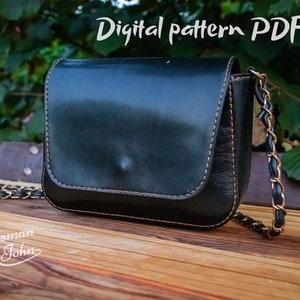 Puede incluir: Bolso bandolera de cuero negro con correa de cadena dorada. El bolso tiene una solapa curva y está cosido con hilo en contraste. El texto "Digital pattern PDF" es visible en la parte superior de la imagen, y el logotipo "The Craftsman John" está en la parte inferior.