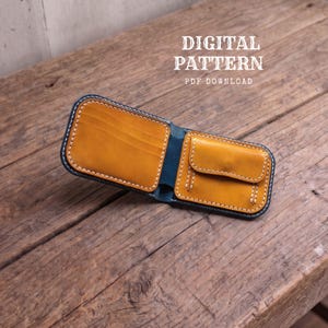 Könnte beinhalten: Ein Bifold-Portemonnaie mit senfgelbem Innenraum, Münzfach und Kartenfächern, abgesetzt durch dunkelblaue Kanten und weiße Nähte. Der Text DIGITAL PATTERN PDF DOWNLOAD ist über dem geöffneten Portemonnaie zu sehen.