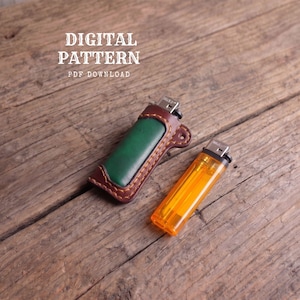 May include: A green leather lighter case with brown stitched edges and a metallic top, positioned next to a translucent orange plastic lighter. The text DIGITAL PATTERN PDF DOWNLOAD is visible in the upper portion of the image.