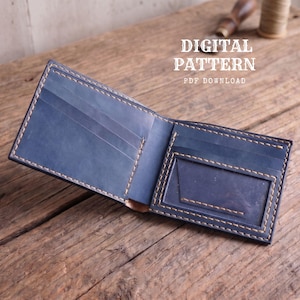 May include: A navy blue leather bifold wallet featuring visible light-coloured stitching, multiple card slots, and a clear ID window. The text DIGITAL PATTERN PDF DOWNLOAD is printed in white above the wallet on a rustic wooden surface.
