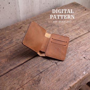 Könnte beinhalten: Ein hellbraunes Lederportemonnaie mit sichtbaren Nähten, das ein Kartenfach und ein Hauptfach aufweist. Der Text DIGITAL PATTERN PDF DOWNLOAD steht über dem Portemonnaie und weist darauf hin, dass es sich um eine Vorlage handelt.