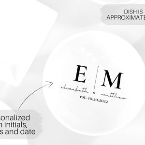 May include: White ceramic dish with black lettering. The dish is personalized with the initials "E" and "M", the names "elizabeth" and "matthew", and the date "est. 10.20.2022". The dish is approximately 4 inches in diameter.