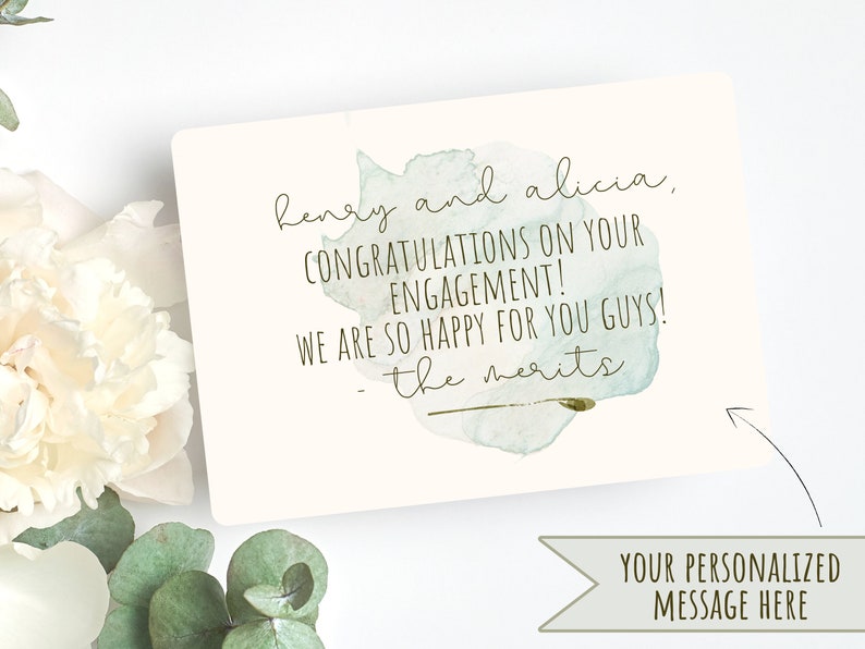 Puede incluir: Una tarjeta de estilo acuarela con un fondo de acuarela verde y azul. La tarjeta dice "henry and alicia, CONGRATULATIONS ON YOUR ENGAGEMENT! WE ARE SO HAPPY FOR YOU GUYS! - the merits".