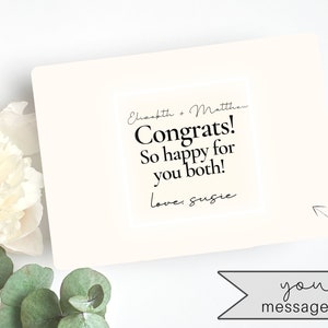 May include: A white card with black text that reads "Elizabeth & Matthew Congrats! So happy for you both! love: Susie" and the words "your message here" in a banner below the card.