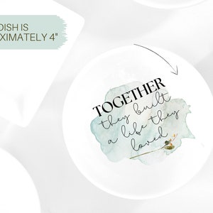 Puede incluir: Un plato de cer&aacute;mica blanco con un dise&ntilde;o de acuarela y el texto "TOGETHER they built a life they loved". El plato tiene un di&aacute;metro de aproximadamente 10 cm.