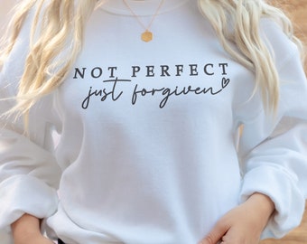 May include: White sweatshirt with the text "NOT PERFECT just forgiven" and a small heart symbol.
