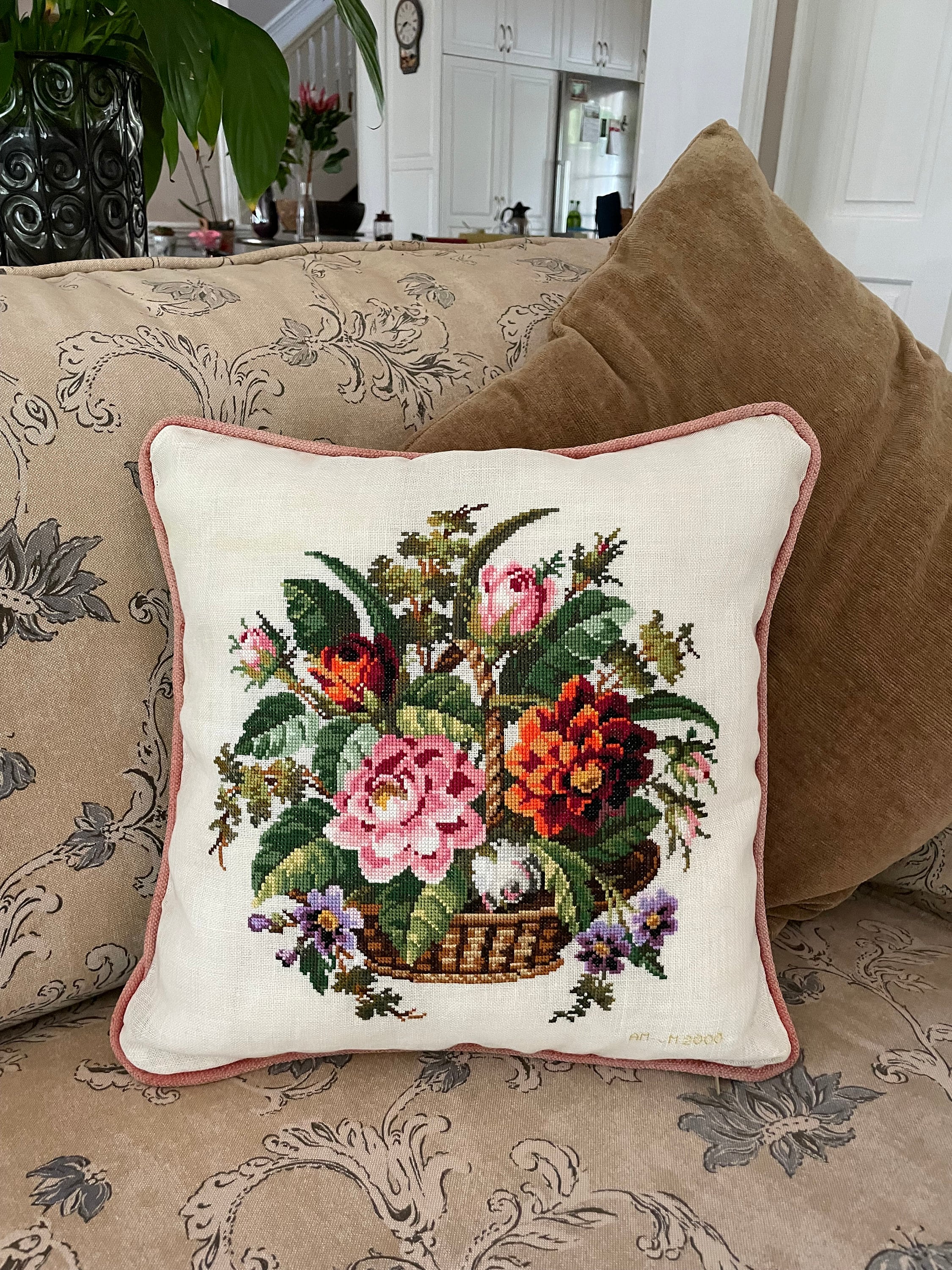 Cushion cover of a hand embroidered cross stitch of a garden floral bouquet in a wicker basket