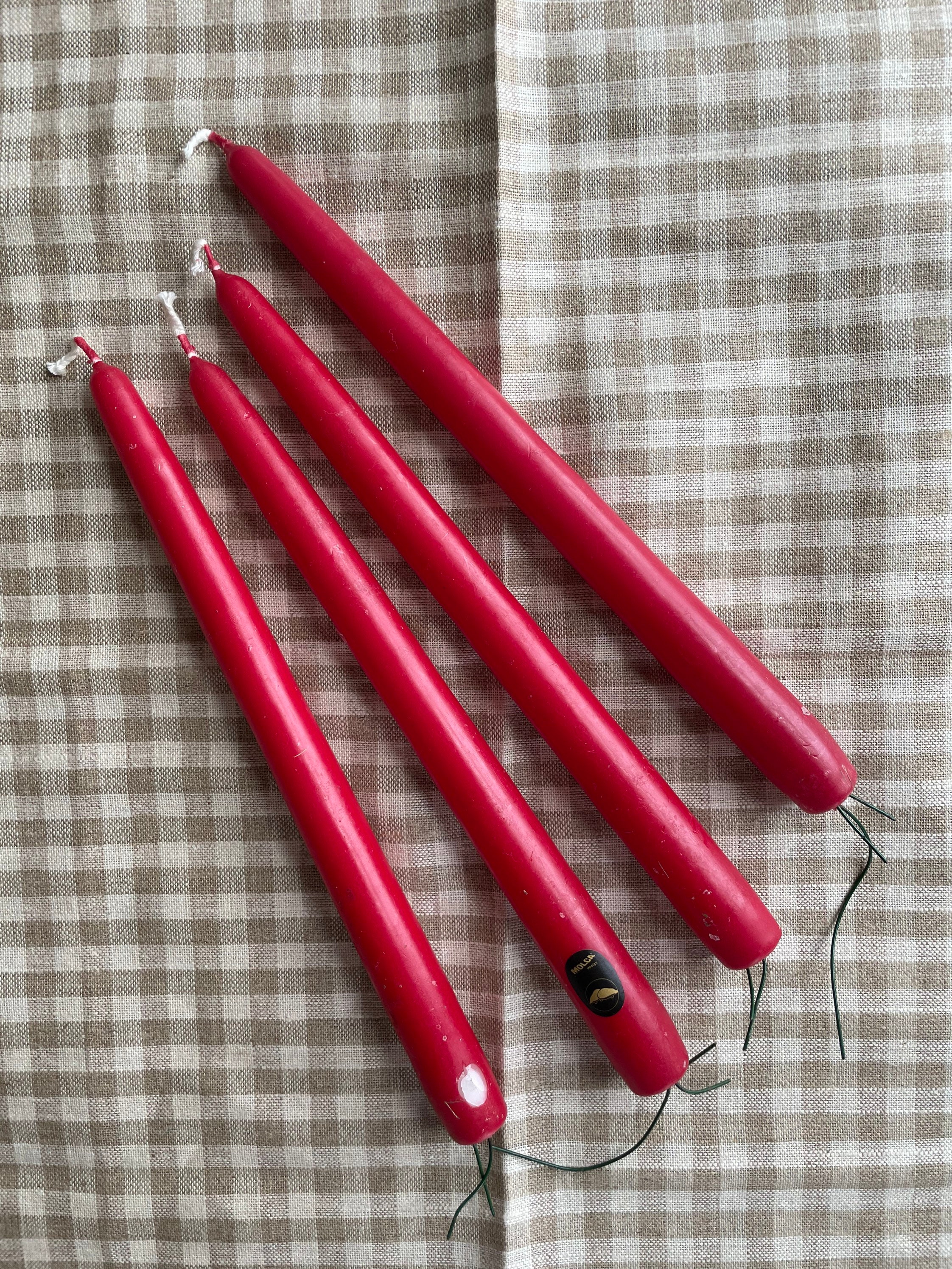 Four special vintage red tapered candle sticks with metal wire to support standing in a decoration