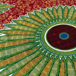 May include: Close-up of a vibrant fabric with a repeating floral pattern. The design features large, stylized flowers in shades of green, yellow, and blue, set against a deep red background. The fabric has a textured appearance.