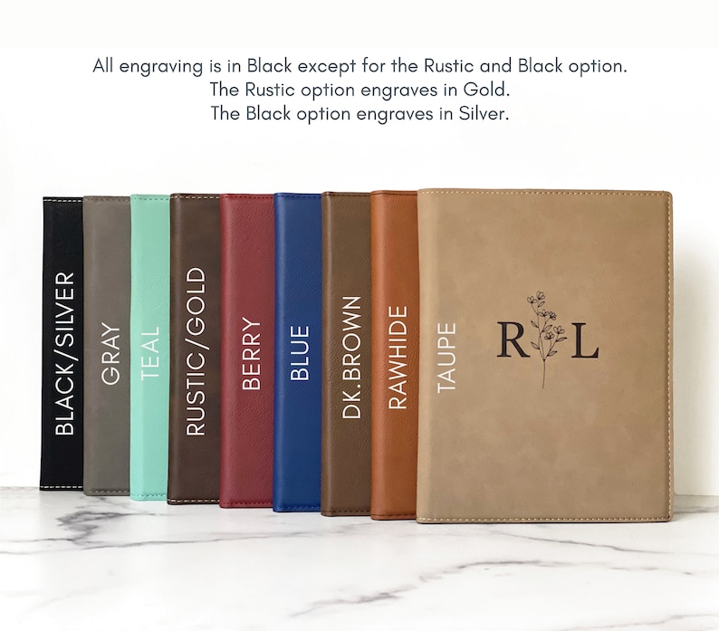 Peut inclure: Neuf carnets reli&eacute;s en cuir de diff&eacute;rentes couleurs avec diff&eacute;rentes options de gravure. Les carnets sont dispos&eacute;s en rang&eacute;e de gauche &agrave; droite. Les options de gravure sont&nbsp;: Noir/Argent, Gris, Sarcelle, Rustique/Or, Baie, Bleu, Brun fonc&eacute;, Crue, Taupe. Le carnet le plus &agrave; droite porte les initiales &laquo;&nbsp;R L&nbsp;&raquo; grav&eacute;es.