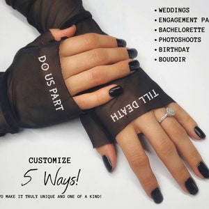 May include: Black mesh fingerless gloves with white embroidery that reads "Do Us Part" on one glove and "Till Death" on the other. The gloves are worn by a person with black nail polish and a diamond ring on their finger.
