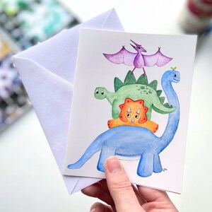 Dinosaurs Stack Watercolor Greeting Card – Triceratops, Stegosaurus & Pterodactyl Dino Note Card, Fun Dinosaur Lover Stationery