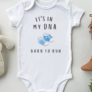 May include: White baby onesie with blue baby shoes and the text "It's in my DNA Born to Run".