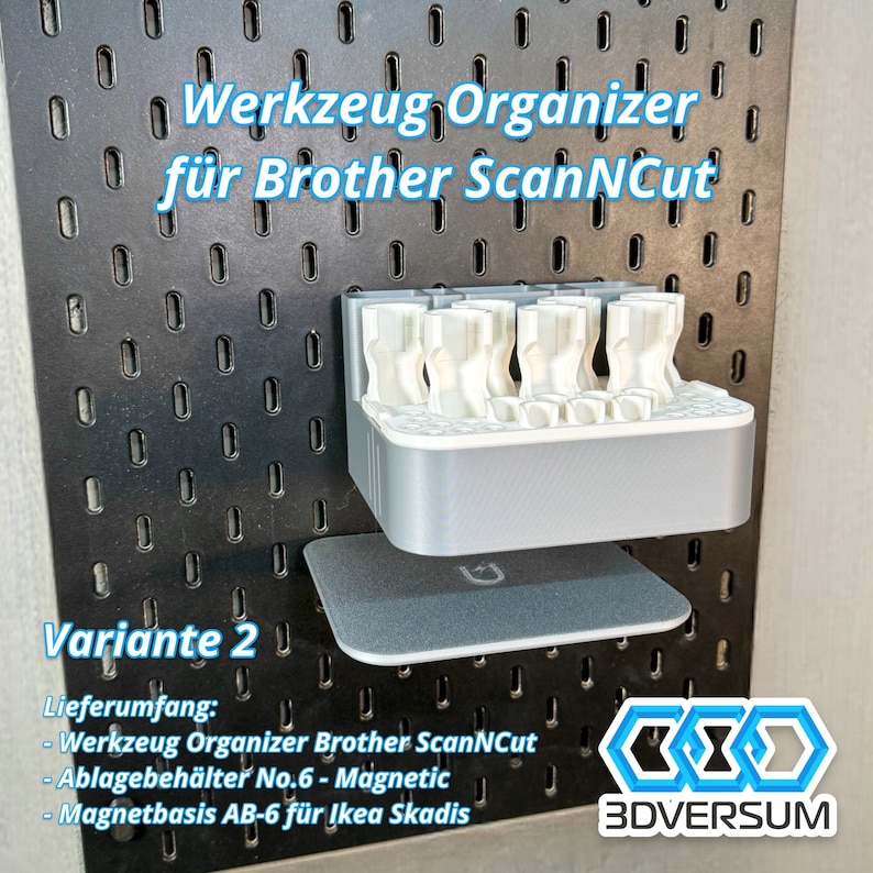 May include: A gray and white tool organizer for Brother ScanNCut, mounted on a black pegboard. The organizer has multiple compartments and is labeled "Variante 2". Includes the text "3DVERSUM".