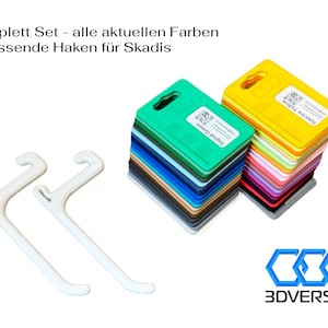 Può includere: Un set di pannelli in plastica colorati in varie tonalità, tra cui verde e giallo, con due ganci bianchi. Il testo sui pannelli recita "Signal Green" e "Spectra Yellow". Il logo 3DVERSUM è in basso a destra.