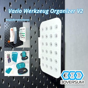Op de afbeelding: Witte plastic gereedschapsorganizer met 36 vakken, met de tekst "Vario Werkzeug Organizer V2" en "3DVERSUM". De organizer is gemonteerd op een zwarte prikbordwand met voorbeelden van hoe de organizer te gebruiken.