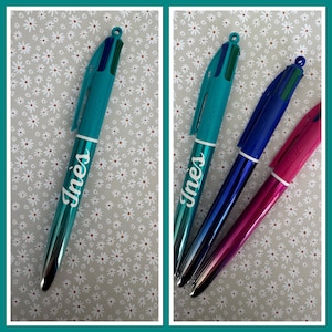 Puede incluir: Tres bolígrafos personalizados con el nombre "Ines" escrito en ellos. Los bolígrafos son de color turquesa, azul y rosa.