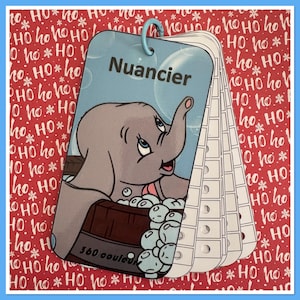 May include: A colour chart with a cartoon elephant in a bathtub with bubbles. The chart is labelled "Nuancier" and has a blue background. The background is a red and white holiday pattern with the words "Ho Ho Ho".