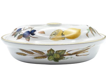 May include: White oval ceramic baking dish with a gold rim and a floral design featuring lemons, blueberries, and wheat.