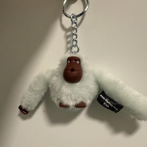 May include: A white ceramic mug with a black handle and the text "But First, Coffee" in a handwritten style. The mug is on a white surface. The mug is 4 inches tall.