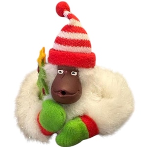 May include: White plush monkey wearing a red and white striped Santa hat and green and red mittens, holding a small green Christmas tree.