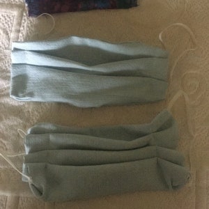 May include: Three face masks, one with a floral pattern and two plain light blue masks.