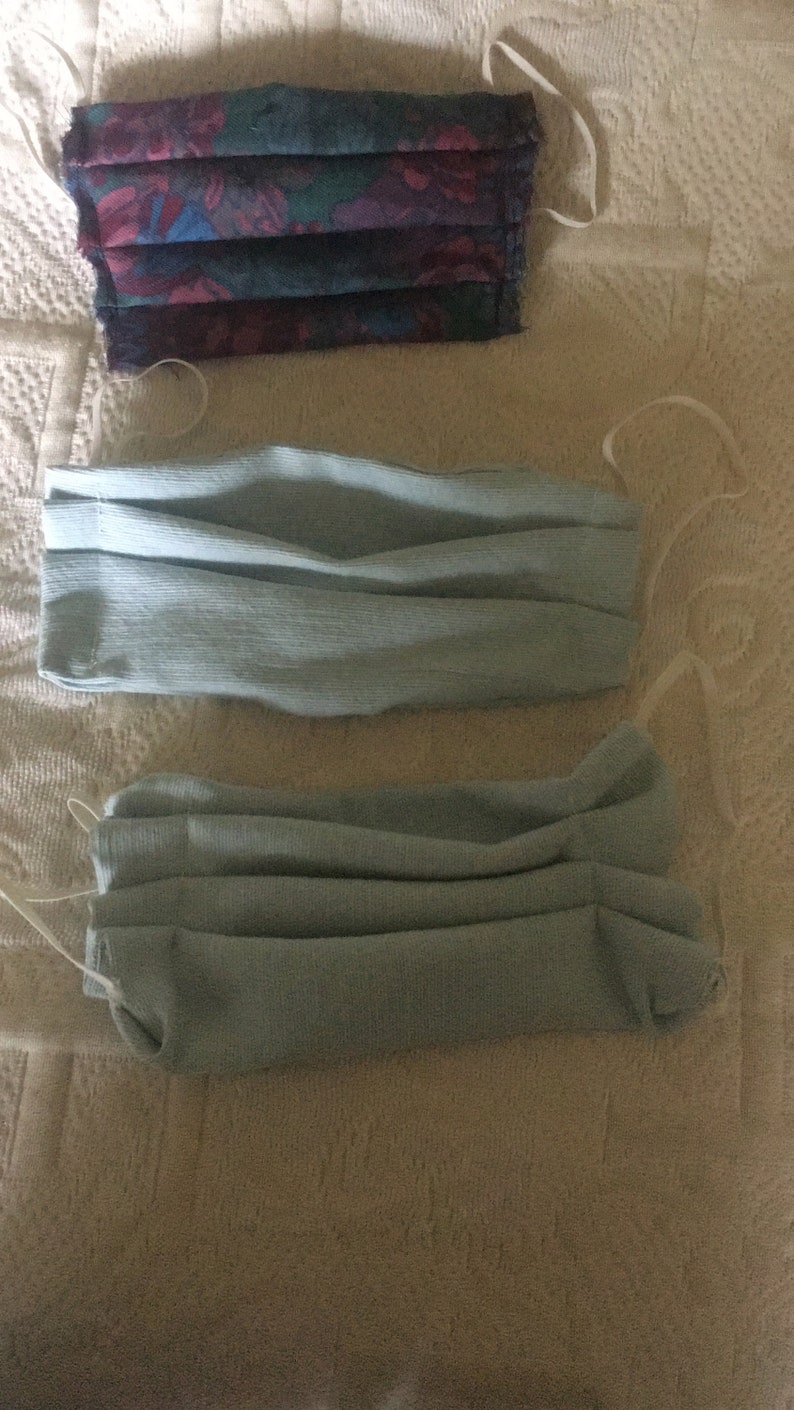 May include: Three face masks, one with a floral pattern and two plain light blue masks.