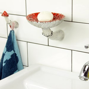 Above the sink in the bathroom is shown an option for placing a hook and shelf in the shape of an mushroom.There is a towel hanging from a hook and face soap on a shelf to the right of it. It is convenient to use these things in such an arrangement