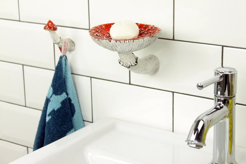 Above the sink in the bathroom is shown an option for placing a hook and shelf in the shape of an mushroom.There is a towel hanging from a hook and face soap on a shelf to the right of it. It is convenient to use these things in such an arrangement