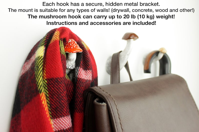 May include: Three mushroom-shaped hooks with a white finish and red and white mushroom caps. The hooks are mounted on a white wall and a brown leather bag is hanging from one of the hooks. The text "Each hook has a secure, hidden metal bracket. The mount is suitable for any types of walls! (drywall, concrete, wood and other!) The mushroom hook can carry up to 20 lb (10 kg) weight! Instructions and accessories are included!" is visible at the top of the image.