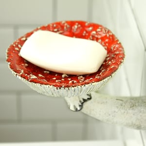 The soap is in a fly agaric hat. The hat has a small indentation in the center for convenience. The leg of the mushroom shelf is attached to the wall, as if a fly agaric grows out of it.