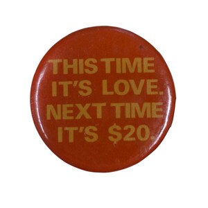 Peut inclure: Un bouton rond orange avec du texte dor&eacute;. Le texte dit : "THIS TIME IT'S LOVE. NEXT TIME IT'S $20."